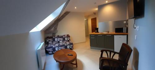 une cuisine avec une petite table et une cuisine avec un évier dans l'établissement Le Mermoz, à Montoire-sur-le-Loir