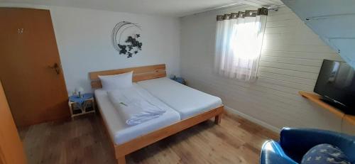 una piccola camera da letto con un letto e una televisione di Hotel-Gasthof Tor zum Steigerwald a Gerolzhofen