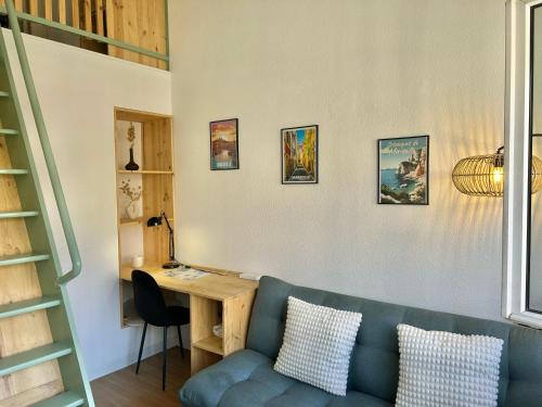 - un salon avec un canapé bleu et un bureau dans l'établissement Chez Martin - Studio tout confort proche Hôpitaux Universitaires Timone Conception - quartier St Pierre, à Marseille