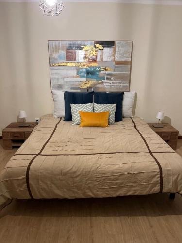 a bedroom with a large bed with a painting on the wall at Quinta de Fonte Coberta in Ponte da Barca