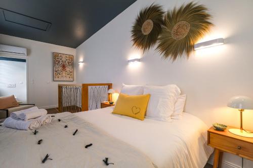 una camera da letto con un grande letto bianco con cuscini di La Pause Albigeoise - Climatisation - Centre Ville ad Albi