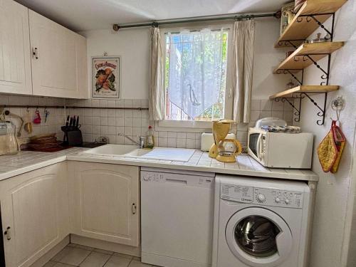 une cuisine avec une machine à laver et une fenêtre dans l'établissement Maison 2 pièces mezzanine 4 couchages ARGELES SUR MER AR150-069, à Argelès-sur-Mer