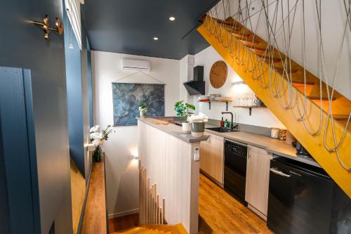une cuisine avec un escalier jaune dans une maison dans l'établissement La Pause Albigeoise - Climatisation - Centre Ville, à Albi