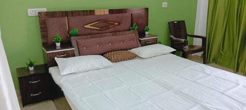 FaizābādShri Balaji Home Stay的卧室里有一张带木质床头板的白色大床