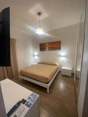 a small bedroom with a bed and a television at R Home in Ischia