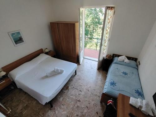 a bedroom with two beds and a sliding glass door at Hotel Silvia Framura - Cinque Terre in Framura