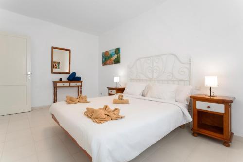 a bedroom with a white bed with towels on it at Casa Queen Vetusta -Pool and Tennis in Arrecife