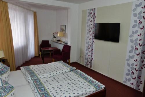 a hotel room with a bed and a flat screen tv at Hotel Am Kurpark in Malente
