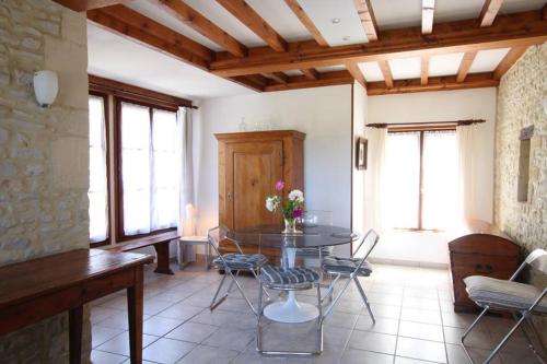 un salon avec une table en verre et des chaises dans l'établissement Le Verger, à Étreham