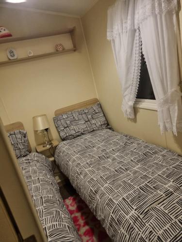 a small bedroom with two beds and a window at fantasy island in Ingoldmells