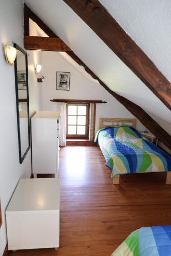 - une chambre mansardée avec 2 lits et une fenêtre dans l'établissement Le Verger, à Étreham