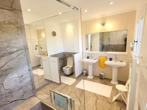 La salle de bains est pourvue de 2 lavabos, de toilettes et d'une douche. dans l'établissement Villa 140 m2 4 étoiles parking wifi - clim - piscine, à Roquebrune-sur Argens