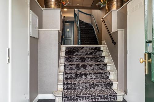 a stairway with a patterned carpet in a hallway at BizStay Maurits in The Hague