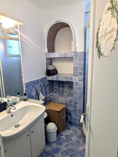 La salle de bains est pourvue de carrelage bleu, d'un lavabo et de toilettes. dans l'établissement Appartement T3 plage et festival, à Cannes
