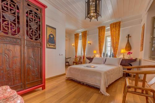 a bedroom with a bed and a large wooden cabinet at Ipekyol Villa avec Piscine Privée in Çeşme