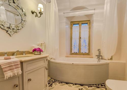 a bathroom with a tub and a sink and a mirror at Ipekyol Villa avec Piscine Privée in Çeşme
