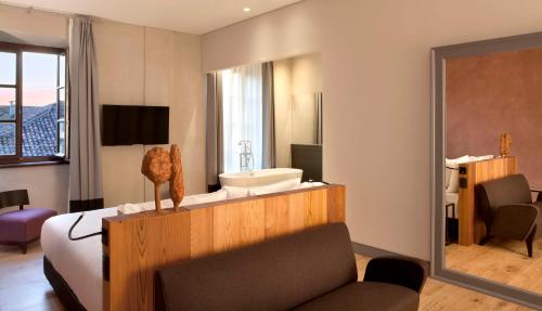 a hotel room with a bed and a sink at NH Collection Torino Piazza Carlina in Turin