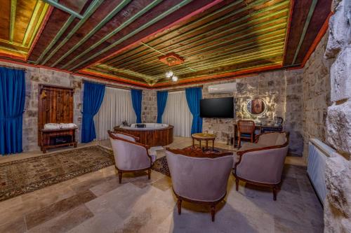 a room with a table and chairs and a tv at Latona Stone Palace in Nevsehir