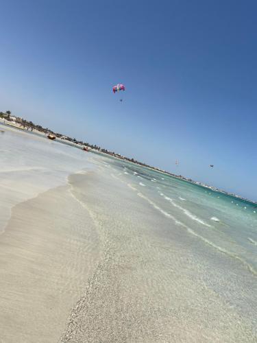 a beach with a kite flying over the ocean at Villa Le Domaine Djerba Piscine Chauffée sans vis à vis in Mezraya