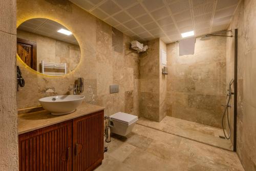 a bathroom with a sink and a toilet and a mirror at Latona Stone Palace in Nevsehir