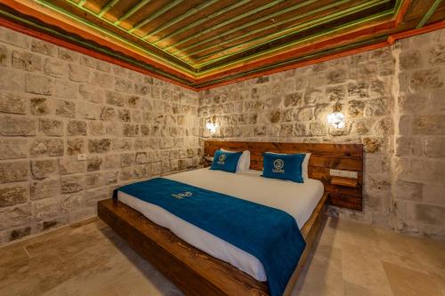 a bedroom with a bed in a stone wall at Latona Stone Palace in Nevsehir