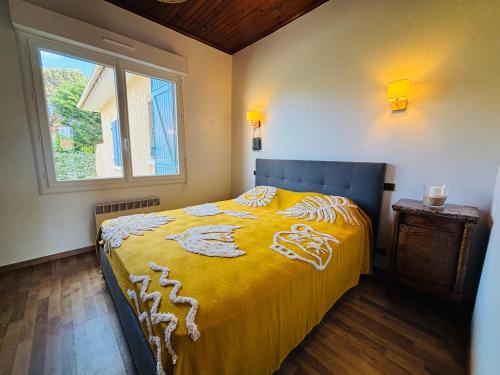 - une chambre avec un lit doté d'une couverture jaune et d'une fenêtre dans l'établissement CHARDONNERET - T3 proche des plages, à Mimizan-Plage