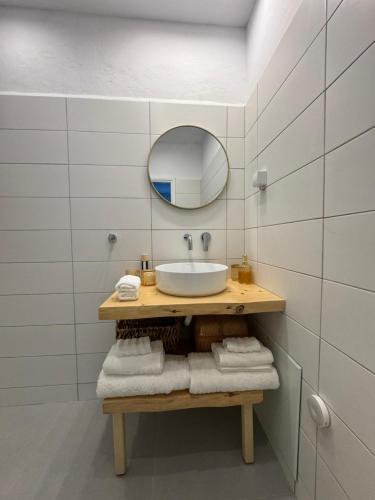 a bathroom with a sink and a mirror and towels at Casa Azul in Kokkari