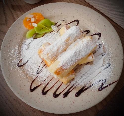 a white plate with two pieces of food on it at Grand Christer Hotel in Kyiv