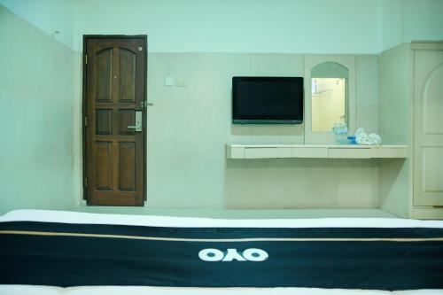 a room with a door and a tv on a wall at Dancenterak Palembang Near Jembatan Ampera Formerly Azzura Hotel in Palembang