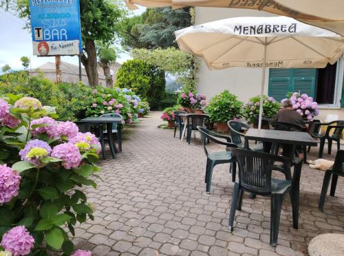 a patio with tables and chairs and flowers at Hotel Silvia Framura - Cinque Terre in Framura