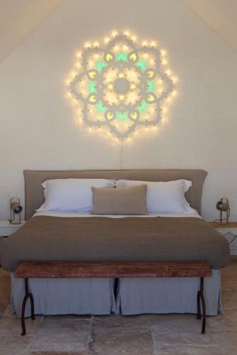 a bedroom with a bed with a chandelier on the wall at Dimora Dei Semplici in Ostuni