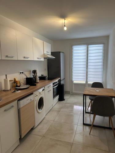 une cuisine avec lave-linge, sèche-linge et une table dans l'établissement Lallie, à Bastia