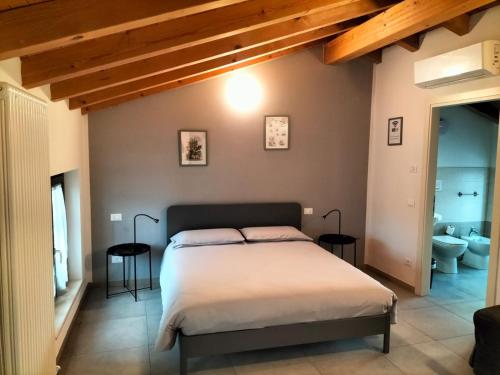 a bedroom with a large bed and a bathroom at La casa della Ada in Castelnuovo del Garda