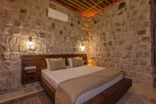 a bedroom with a bed in a stone wall at Latona Stone Palace in Nevsehir