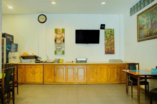 a living room with a television on a wall at Dancenterak Palembang Near Jembatan Ampera Formerly Azzura Hotel in Palembang