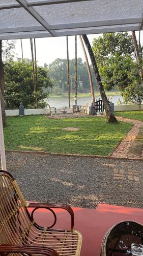 a patio with a bench and a view of a park at The River House in Ernakulam