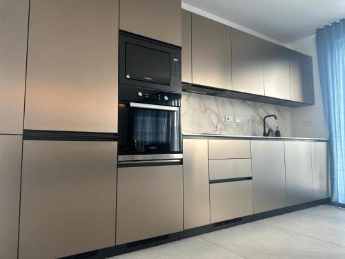 a kitchen with stainless steel appliances and a microwave at Desibu Collection - The Pearl St Julian's in St Julian's