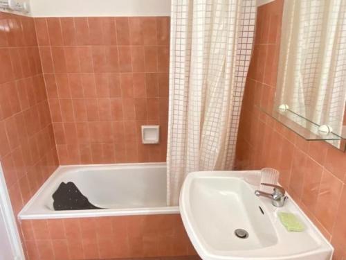 une salle de bain avec un lavabo et une baignoire dans l'établissement Vue mer 180 degrés - Wifi - Parking, à Saint-Raphaël