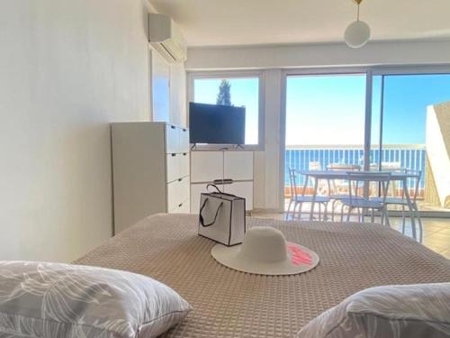 une chambre avec un lit avec un chapeau dessus dans l'établissement Vue mer 180 degrés - Wifi - Parking, à Saint-Raphaël