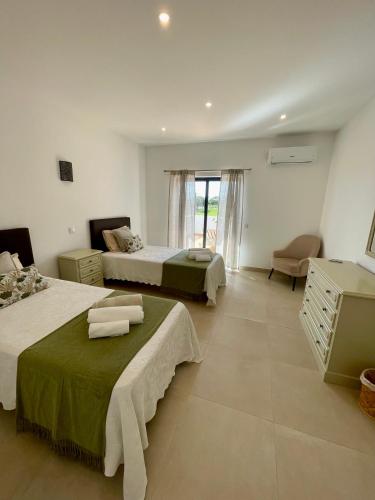 a bedroom with two beds and a dresser at Vila Castelo in Vale do Lobo