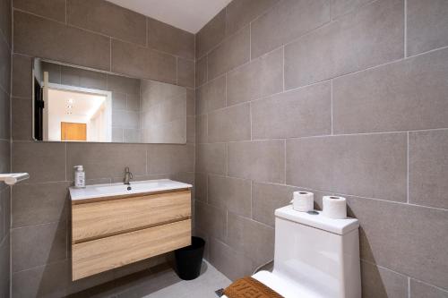 a bathroom with a toilet and a sink and a mirror at Townhouse in Khet Phayathai - Ari in Bangkok