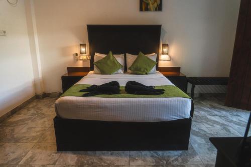 a bedroom with a bed with two robes on it at Sundaras Sigiriya Jungles Caves Resort in Dambulla
