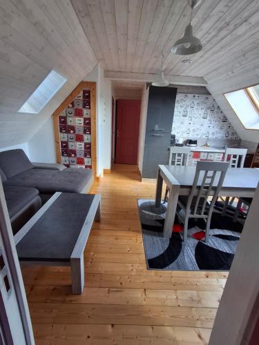 a living room with a table and a couch at Les Roses Des Bois in Murat-le-Quaire