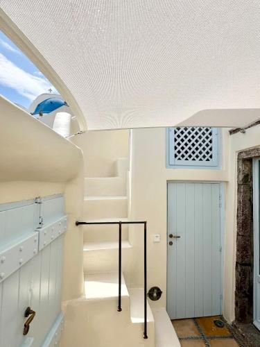 a room with a white staircase and a door at Ilia Oia in Oia