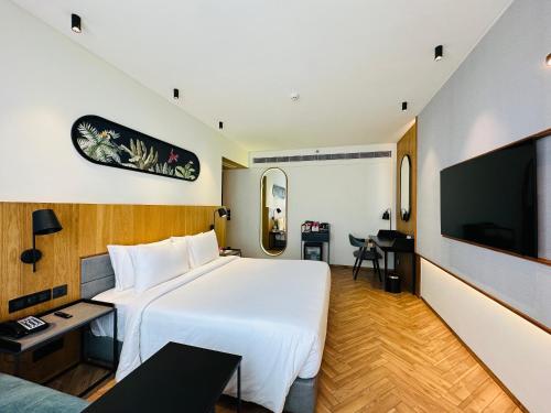 a hotel room with a white bed and a tv at Ramada Encore by Wyndham Ambala GT Road in Ambāla