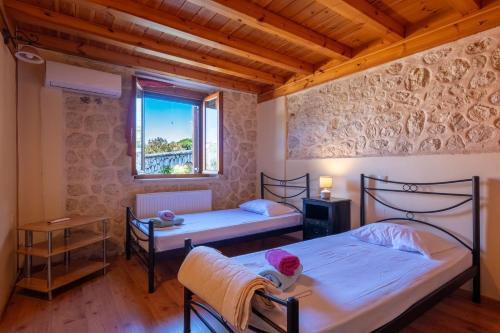 a child sitting on a bed in a room with two beds at Katouna Stone House in Katouna