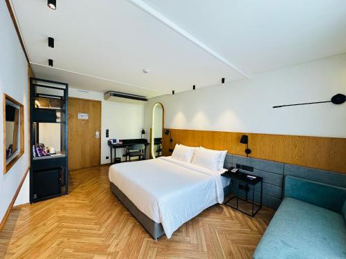 a bedroom with a white bed and a desk and a table at Ramada Encore by Wyndham Ambala GT Road in Ambāla