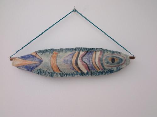 a fish hanging on a string on a wall at Villa Eucalipti immersa nel verde e sul mare in Magazzini