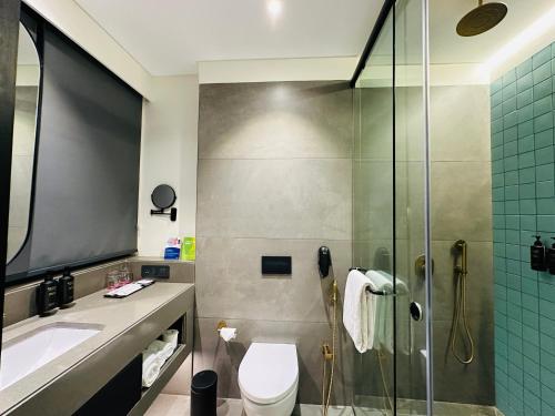 a bathroom with a shower and a toilet and a sink at Ramada Encore by Wyndham Ambala GT Road in Ambāla