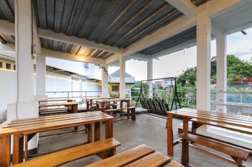 a row of wooden benches sitting on a porch at RedDoorz Syariah near Taman Air Mancur Bogor in Bogor
